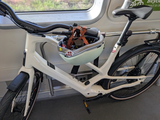 Bike on a train with helmet straps holding down the rear brake lever